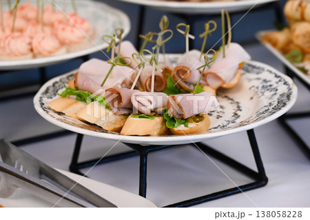 Assorted catering appetizer with ham canape and mustard on baguette for event or party decoration with delicious savory meat snack on buffet table Assorted catering appetizer with ham canape and mustard on baguette for event or party decoration with delicious savory meat snack on buffet table 138058228