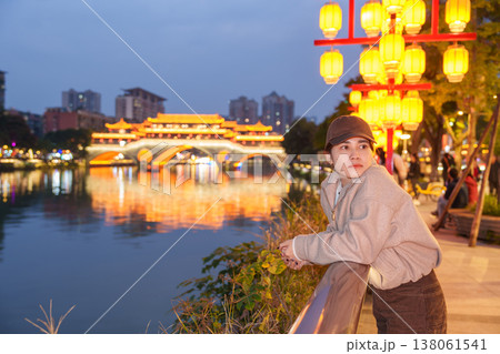 Happy woman traveler travel in Chengdu city. Tourist sightseeing Beautiful Anshun Bridge at night. Famous Landmark for tourism attraction in Sichuan, China 138061541