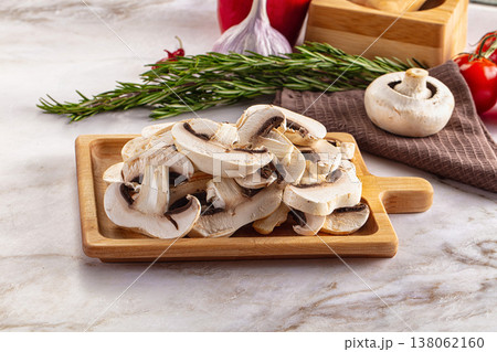 Raw champignon slices on the board 138062160