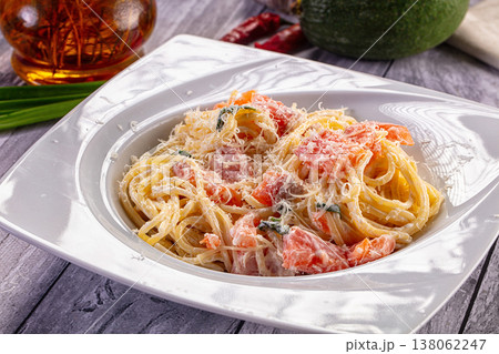 Creamy spaghetti pasta with salmon and grated parmesan cheese on a rustic wooden table. Creamy spaghetti pasta with salmon and grated parmesan cheese on a rustic wooden table. 138062247