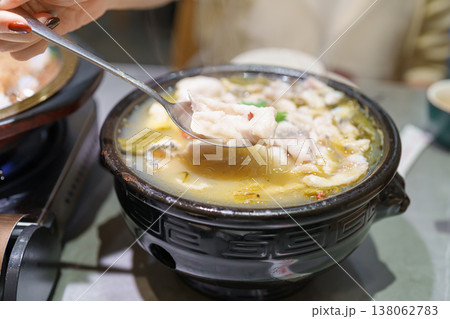 Woman tourist eating Sichuan Fish with Pickled Mustard Greens or Suan Cai Yu in restaurant. Popular foods for tourist eating in Chengdu, Chongqing and China. Chinese Asia and Sichuan foods concept 138062783