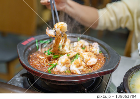 Woman tourist eating baked shrimp with glass noodles and garlic in restaurant. Popular foods for tourist eating in Chengdu, China. Chinese Asia and Sichuan foods concept 138062784