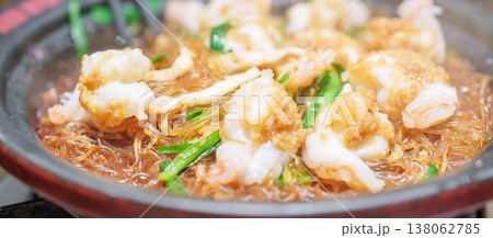 Woman tourist eating baked shrimp with glass noodles and garlic in restaurant. Popular foods for tourist eating in Chengdu, China. Chinese Asia and Sichuan foods concept 138062785