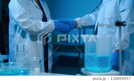 Scientists Shaking Hands in Laboratory Representing Teamwork, Success, and Medical Research Collaboration. Scientists Shaking Hands in Laboratory Representing Teamwork, Success, and Medical Research Collaboration. 138064057