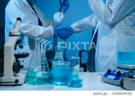 Scientists Shaking Hands in Laboratory Representing Teamwork, Success, and Medical Research Collaboration. 138064059