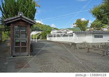 伝統的な白壁の塀と瓦屋根の木製電話ボックスが調和する愛媛県内子中学校の正門風景 伝統的な白壁の塀と瓦屋根の木製電話ボックスが調和する愛媛県内子中学校の正門風景 138064128