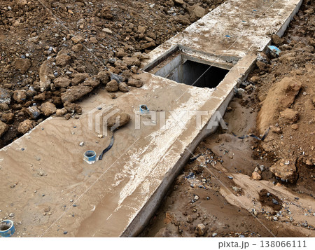 Narrow ditch with reinforcement, waterproof concrete trench bounded by soil and support stakes Narrow ditch with reinforcement, waterproof concrete trench bounded by soil and support stakes 138066111