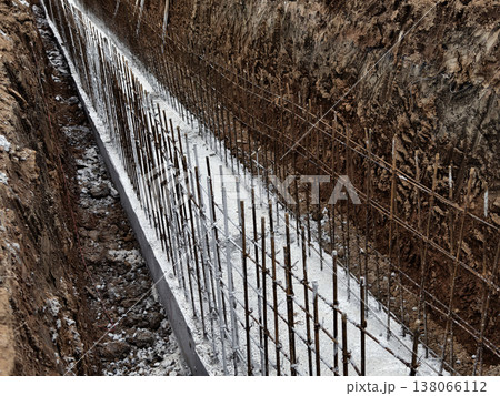 Narrow ditch with reinforcement, waterproof concrete trench bounded by soil and support stakes Narrow ditch with reinforcement, waterproof concrete trench bounded by soil and support stakes 138066112