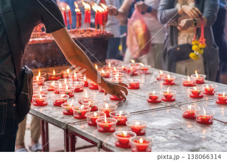 Placing candles at temple table 138066314