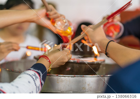 Hands lighting incense together 138066316