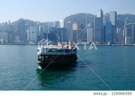 Iconic Star Ferry crossing Victoria Harbour with Hong Kong island skyline in background sunny day 138066389