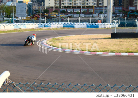 Motorcycle racer on colorful racing bike speeding on Macau Grand Prix street circuit track sunny day Motorcycle racer on colorful racing bike speeding on Macau Grand Prix street circuit track sunny day 138066431
