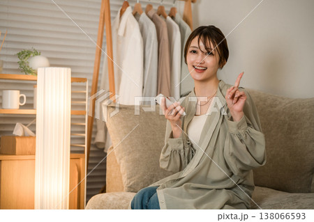 夜のリビングのソファでスマホを見ながらくつろぐ若いアジア人女性(ポイント,おすすめ,案内,紹介) 夜のリビングのソファでスマホを見ながらくつろぐ若いアジア人女性(ポイント,おすすめ,案内,紹介) 138066593