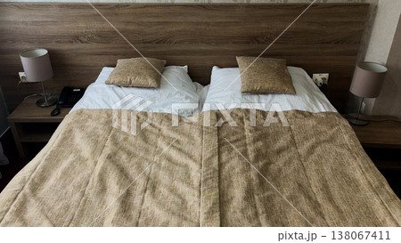 Bed covered with brown bedspread, white pillows.  138067411