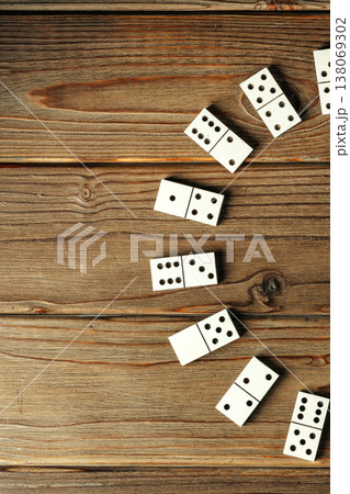 People play a game with white dominoes on a wooden table in the afternoon 138069302