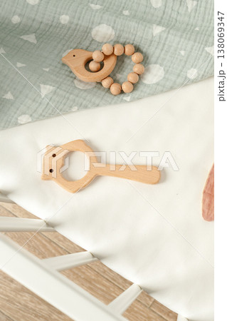 Wooden toys and baby accessories on a light fabric surface in a bright room setting 138069347