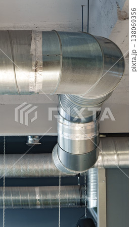 Pipes and ducts on the ceiling in a modern building during daylight hours 138069356