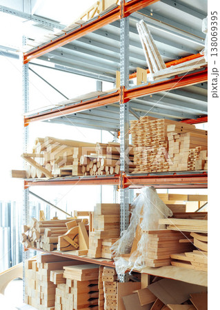 Wood materials are organized on shelves in a storage area during the day 138069395