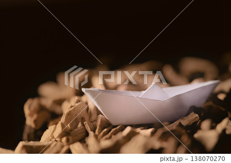 Paper Boat on Wood Chips in Warm Light Paper Boat on Wood Chips in Warm Light 138070270