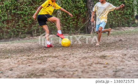 Boys Playing Soccer on Dirt Field 138072575