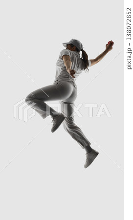 Female cricket bowler back view mid air preparing throw isolated. Female cricket bowler back view mid air preparing throw isolated. 138072852