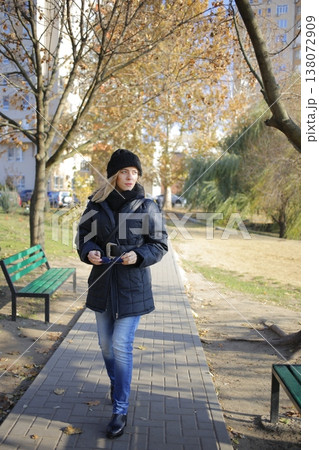 A young woman walks through the autumn park. A young woman walks through the autumn park. 138072909
