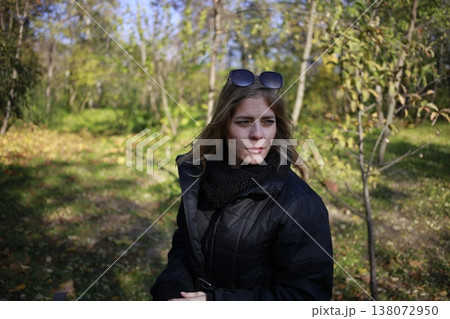 A young woman walks through the autumn park. 138072950
