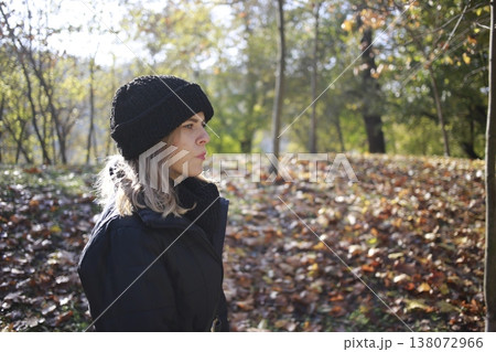 A young woman walks through the autumn park. A young woman walks through the autumn park. 138072966