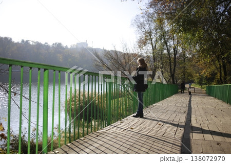 A young woman walks through the autumn park. A young woman walks through the autumn park. 138072970