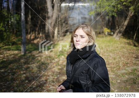 A young woman walks through the autumn park. A young woman walks through the autumn park. 138072978