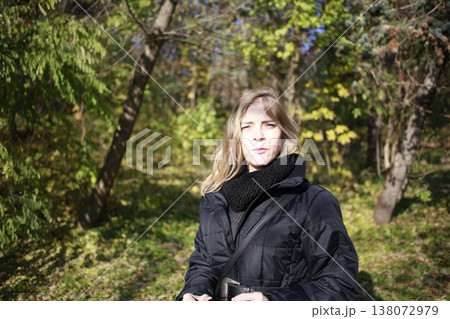 A young woman walks through the autumn park. A young woman walks through the autumn park. 138072979