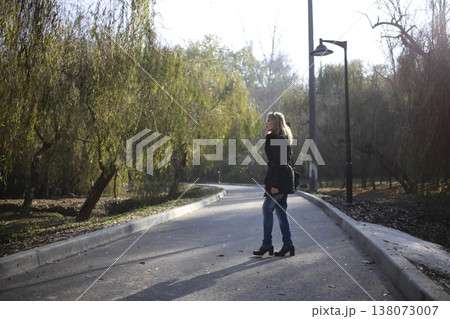 A young woman walks through the autumn park. A young woman walks through the autumn park. 138073007
