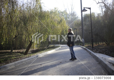 A young woman walks through the autumn park. A young woman walks through the autumn park. 138073008