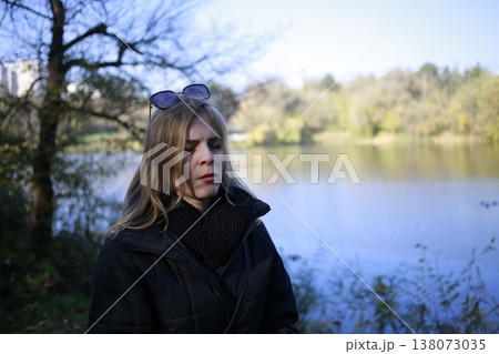 A young woman walks through the autumn park. 138073035