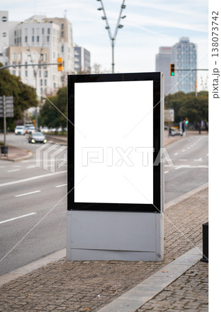Vertical blank digital billboard mockup on a city street, displaying advertising space in an urban environment with traffic and buildings in the background Vertical blank digital billboard mockup on a city street, displaying advertising space in an urban environment with traffic and buildings in the background 138073742