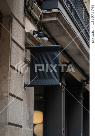 Blank black vertical banner flag hanging on an old stone building wall in an urban street, providing a template for branding, advertising, and company identity mockup Blank black vertical banner flag hanging on an old stone building wall in an urban street, providing a template for branding, advertising, and company identity mockup 138073748