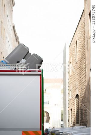 Moving truck carrying containers through a narrow European city alley, navigating historic urban streets surrounded by old brick buildings, suggesting a scene of transport and relocation 138073749