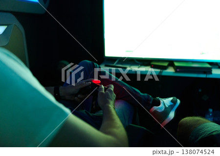 Young Man Playing Video Game With Controller On Couch In Dark Living Room Young Man Playing Video Game With Controller On Couch In Dark Living Room 138074524