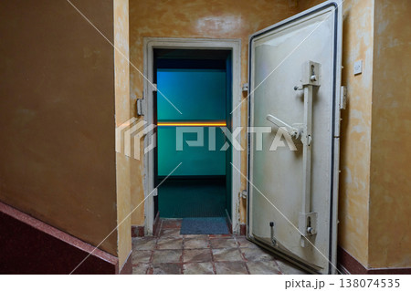 Open Vault Door in Dimly Lit Interior Corridor With Teal Light and Heavy Metal Hatch Open Vault Door in Dimly Lit Interior Corridor With Teal Light and Heavy Metal Hatch 138074535