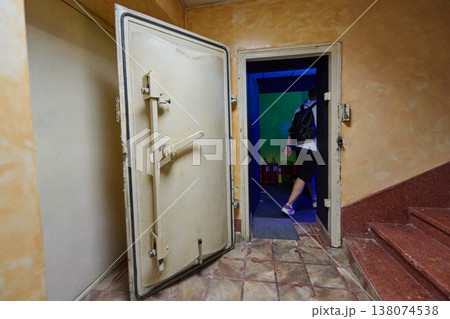 Person Walking Through Open Vault Door Into Dimly Lit Underground Room With Backpack Person Walking Through Open Vault Door Into Dimly Lit Underground Room With Backpack 138074538