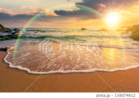 sunset over sandy sea beach. scene on hot summer vacation season. beautiful view of waves washing the sand. generic image of seascape and sky with rainbow for advertising background sunset over sandy sea beach. scene on hot summer vacation season. beautiful view of waves washing the sand. generic image of seascape and sky with rainbow for advertising background 138074612