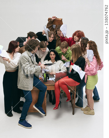 Office workers crowding female manager with papers, chaotic workflow and pressure in studio. Office workers crowding female manager with papers, chaotic workflow and pressure in studio. 138074762