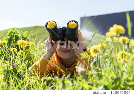 Young smiling woman looking through binoculars with dandelion flowers inside lenses in meadow Curious woman exploring nature in spring Creative discovery concept Outdoor activity, Taraxacum officinale Young smiling woman looking through binoculars with dandelion flowers inside lenses in meadow Curious woman exploring nature in spring Creative discovery concept Outdoor activity, Taraxacum officinale 138075094