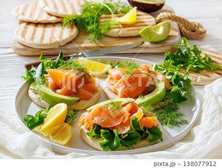 open-faced grilled pita sandwiches with lettuce, smoked salmon slices, avocado, dill, and lemon wedges open-faced grilled pita sandwiches with lettuce, smoked salmon slices, avocado, dill, and lemon wedges 138077912