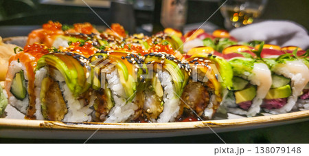 Colorful sushi rolls arranged on a decorative plate with vibrant toppings 138079148