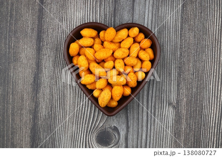 Crunchy Coated Peanuts in a Heart Shaped Bowl Isolated on White Background Crunchy Coated Peanuts in a Heart Shaped Bowl Isolated on White Background 138080727