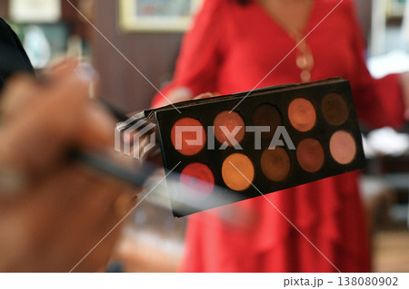 Bridal makeup artist holding eyeshadow palette during cozy morning preparations for wedding Bridal makeup artist holding eyeshadow palette during cozy morning preparations for wedding 138080902