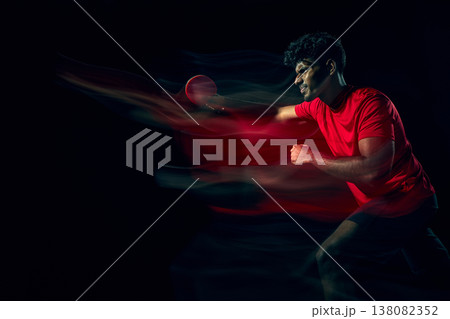 Table tennis player with motion blur effect showing speed and dynamic movement in dark studio 138082352