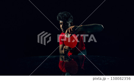 Table tennis player competing for point in dark studio with reflection surface. Table tennis player competing for point in dark studio with reflection surface. 138082356