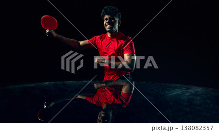 Table tennis player reacting to fast ball in dark studio with reflection surface. Table tennis player reacting to fast ball in dark studio with reflection surface. 138082357